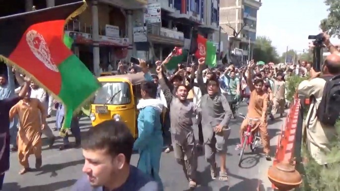 People carry Afghan flags as they take part in an anti-Taliban protest in Jalalabad, Afghanistan