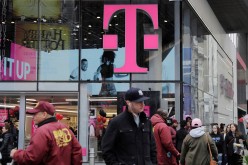 Pedestrians walk past a T-Mobile store in New York, U.S