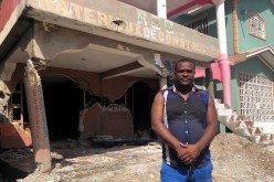 Rosemond Clermont poses for a photo outside his contruction business that was destroyed in a 7.2 magnitude quake, in Les Cayes, Haiti 
