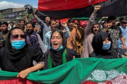 People carry the national flag at a protest held during the Afghan Independence Day in Kabul, Afghanistan