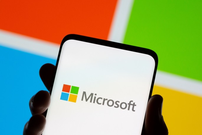 Smartphone is seen in front of Microsoft logo displayed in this illustration taken,