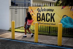 A student wearing a protective masks, walks past a “Welcome back” banner on the first day of school, amid the coronavirus disease (COVID-19) pandemic, at St. Lawrence Catholic School in North Miami Beach, Florida, U.S.