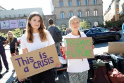 Swedish climate activist Greta Thunberg and German climate activist Luisa Neubauer hold placards during a protest outside the Swedish Parliament as part of Fridays