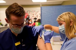 Fourth-year medical student Anna Roesler administers the Pfizer-BioNTech coronavirus disease (COVID-19) vaccine at Indiana University Health,