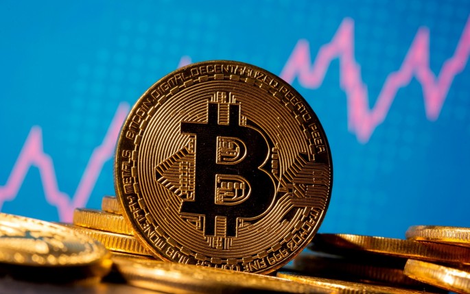 A representation of virtual currency bitcoin is seen in front of a stock graph in this illustration taken 