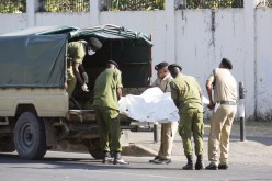 Tanzanian security forces remove the slain body of an attacker who was wielding an assault rifle, outside the French embassy in the Salenda area of Dar es Salaam,