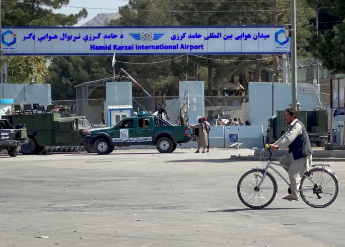 Taliban stand at the entrance gate of Hamid Karzai International airport while Taliban forces block the roads around the airport after yesterday's explosions in Kabul,