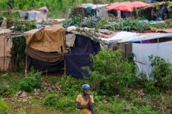 A woman stands in front of a tent encampment built after the August 14 earthquake destroyed houses and infrastructure in the Nan Konsey neighborhood of Pestel, Haiti 