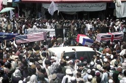 Crowd carries makeshift coffins draped in NATO's, U.S. and a Union Jack flags during a pretend funeral on a street in Khost, Afghanistan