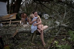 Tiffany Miller is embraced by her daughter Desilynn, 6, as she holds her one year old godchild Charleigh, after the family returned to their destroyed home in the aftermath of Hurricane Ida in Golden Meadow, Louisiana, U.S.