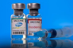 Vials with Pfizer-BioNTech and Moderna coronavirus disease (COVID-19) vaccine labels are seen in this illustration picture taken