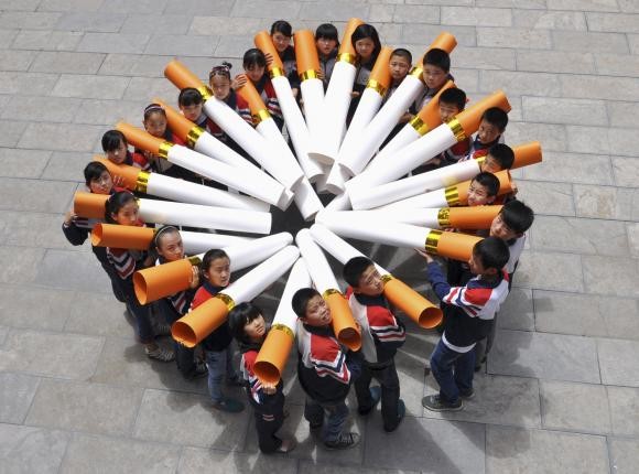 Students pose for pictures with ''big cigarette models'' for a campaign.