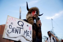 Jacob Chansley, holding a sign referencing QAnon, speaks as supporters of U.S. President Donald Trump gather to protest about the early results of the 2020 presidential election