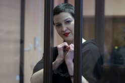 Belarusian opposition politician Maria Kolesnikova, charged with extremism and trying to seize power illegally, gestures inside a defendants' cage as she attends a court hearing in Minsk