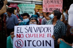 A person holds a sign that reads 'El Salvador doesn't want Bitcoin' as people participate in a protest against the use of Bitcoin as legal tender, in San Salvador, El Salvador,
