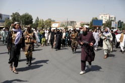 Taliban soldiers stand in front of protesters during the anti-Pakistan protest in Kabul, Afghanistan