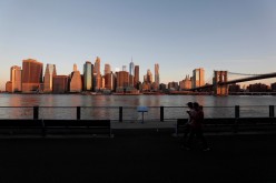 People walk as the New York skyline and the Brooklyn Bridge are seen on the 20th anniversary of the