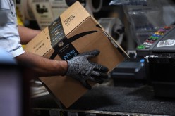 A worker assembles a box for delivery at the Amazon fulfillment center in Baltimore, Maryland, U.S.,