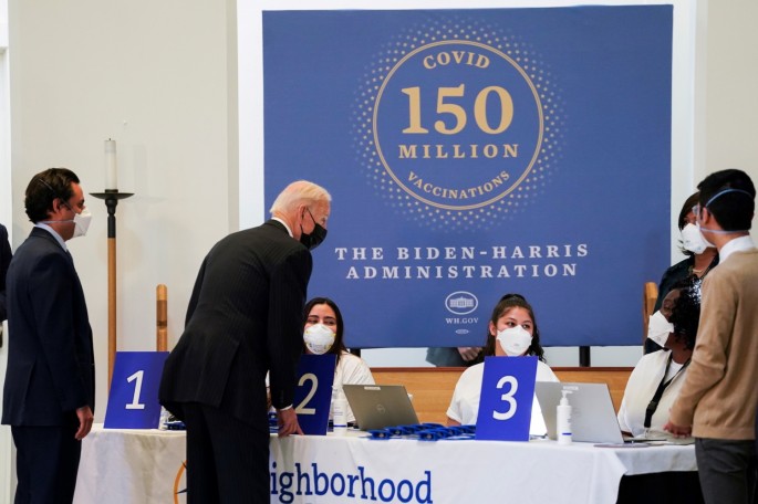 U.S. President Joe Biden speaks with medical workers during a visit to a coronavirus disease (COVID-19) vaccination site at Virginia Theological Seminary in Alexandria, Virginia, U.S.