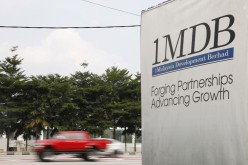 Traffic passes a 1Malaysia Development Berhad (1MDB) billboard at the Tun Razak Exchange development in Kuala Lumpur, Malaysia,