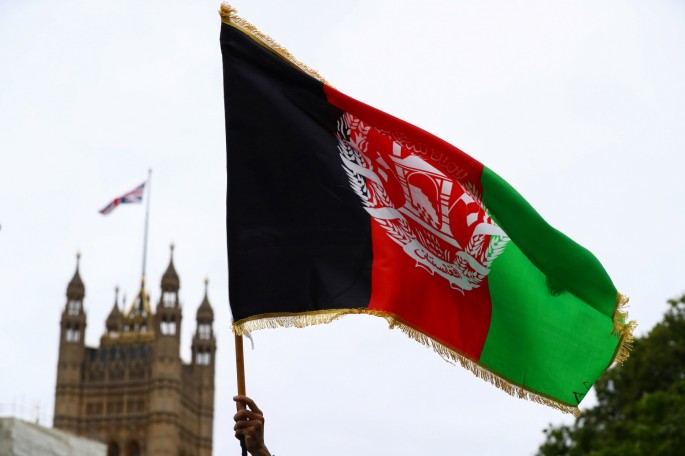 A demonstrator holds an Afghan flag during a "Save Afghanistan" protest in Parliament Square, in London, Britain,
