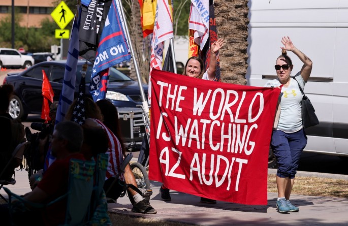 People hold a banner outside the Senate during the announcement of interim findings from a widely criticized audit of the 2020 election in Phoenix, Arizona, U.S