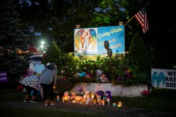 People place candles and flowers during a candlelight vigil for travel blogger Gabby Petito, whose body was discovered in a remote corner of the Bridger-Teton National Forest after travelling with her boyfriend, in Blue Point, New York, U.S., 
