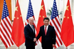 Chinese President Xi Jinping shakes hands with then-U.S. Vice President Joe Biden (L) inside the Great Hall of the People in Beijing