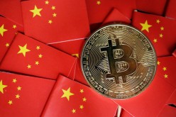 A representation of Bitcoin cryptocurrency is seen amid China's flags in this illustration picture taken