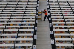 A worker collects orders at Amazon's fulfilment centre in Rugeley, central England
