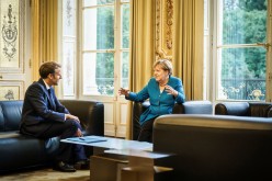 French President Emmanuel Macron talks to German Chancellor Angela Merkel at the Elysee Palace in Paris, France,