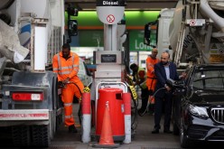 People refuel their vehicles at a fuel station in London, Britain,