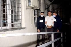 Georgia's former President Mikheil Saakashvili, who was detained after returning to the country, is escorted by police officers as he arrives at a prison in Rustavi,