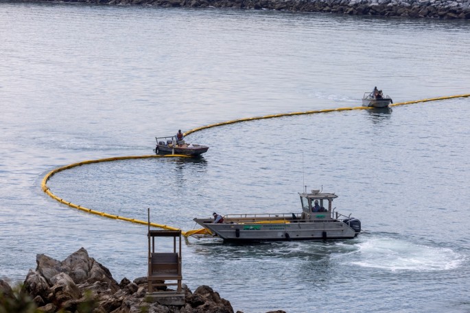 Workers seal off the entrance to Newport Beach harbor as a major oil spill off the coast of California travels south in ocean currents, towards Newport Beach, California, U.S.