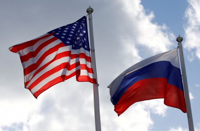 Russian and U.S. state flags fly near a factory in Vsevolozhsk, Leningrad Region, Russia
