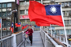 A man walks on an overpass decorated with Taiwan flags to celebrate the upcoming National Day in Taipei, Taiwan, 