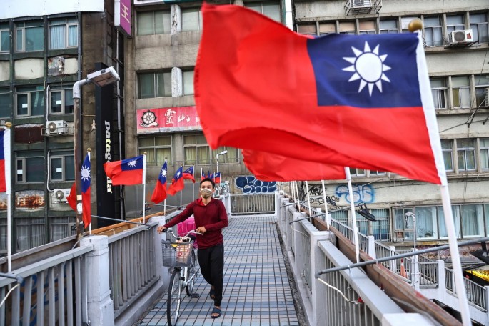 A man walks on an overpass decorated with Taiwan flags to celebrate the upcoming National Day in Taipei, Taiwan, 