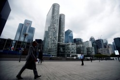 People walk through the financial and business district of La Defense in Puteaux near Paris, France,