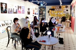 Fans of K-pop idol boy band BTS enjoy as they watch a live streaming online concert, wearing a protective masks to avoid the spread of the coronavirus disease (COVID-19), at a cafe in Seoul, South Korea 