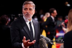 Director George Clooney speaks to the media as he arrives for a screening of the film 