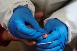 A medical worker takes a blood sample from a saleswoman during a voluntary rapid antigen testing campaign for the coronavirus disease (COVID-19) at the Sopocachi market in La Paz, Bolivia,
