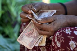 A woman counts Ethiopian birr notes, after selling a cabbage at the Mercato market in Addis Ababa 