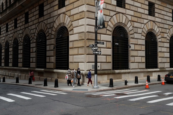 People walk wearing masks outside The Federal Reserve Bank of New York in New York City,