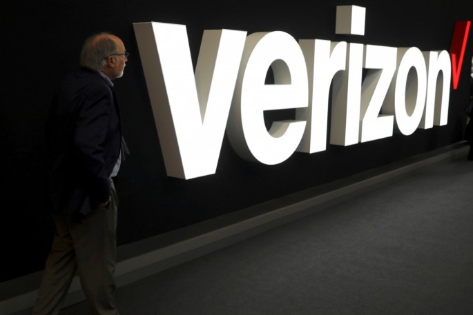 A man stands next to the logo of Verizon at the Mobile World Congress in Barcelona, Spain,