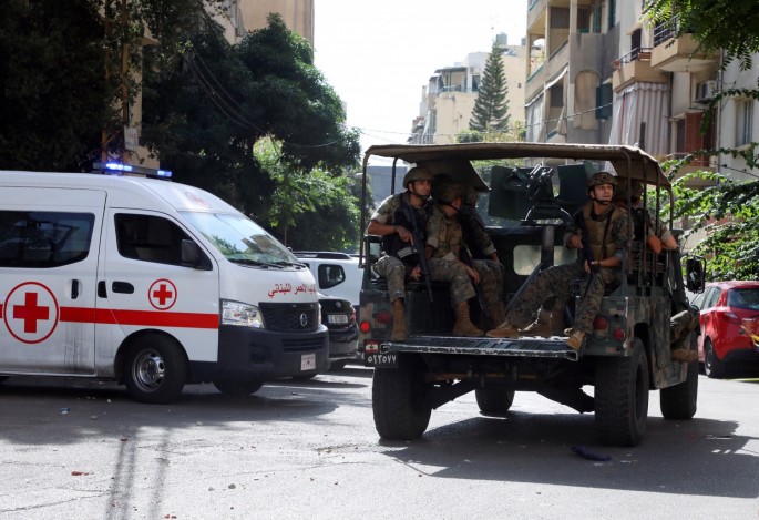 A Lebanese Red Cross vehicle is pictured as army soldiers are deployed after gunfire erupted near the site of a protest that was getting underway against Judge Tarek Bitar, who is investigating last year's port explosion, in Beirut, Lebanon