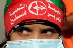 A girl wearing a protective face mask and the headband of the Popular Front for the Liberation of Palestine (PFLP) looks on during a rally to show solidarity with hunger-striking Palestinian prisoner Maher Al-Akhras, who is held by Israel, in Gaza City