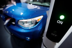 A Kia Soul EV is plugged into a charging station during the second press day of the North American International Auto Show in Detroit, Michigan,