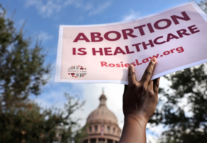 A supporter of reproductive rights holds a sign outside the Texas State Capitol building during the nationwide Women's March, held after Texas rolled out a near-total ban on abortion procedures and access to abortion-inducing medications