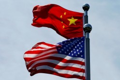 Chinese and U.S. flags flutter near The Bund, in Shanghai, China,