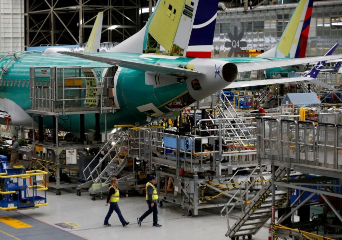 Employees walk by the end of a 737 Max aircraft at the Boeing factory in Renton, Washington, U.S.
